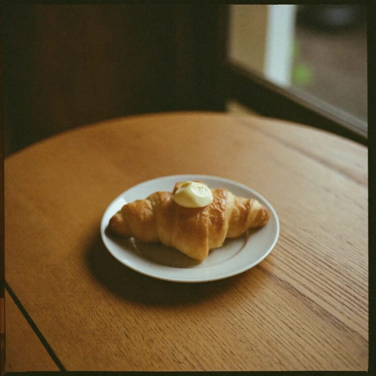 A butter croissant on a small white plate